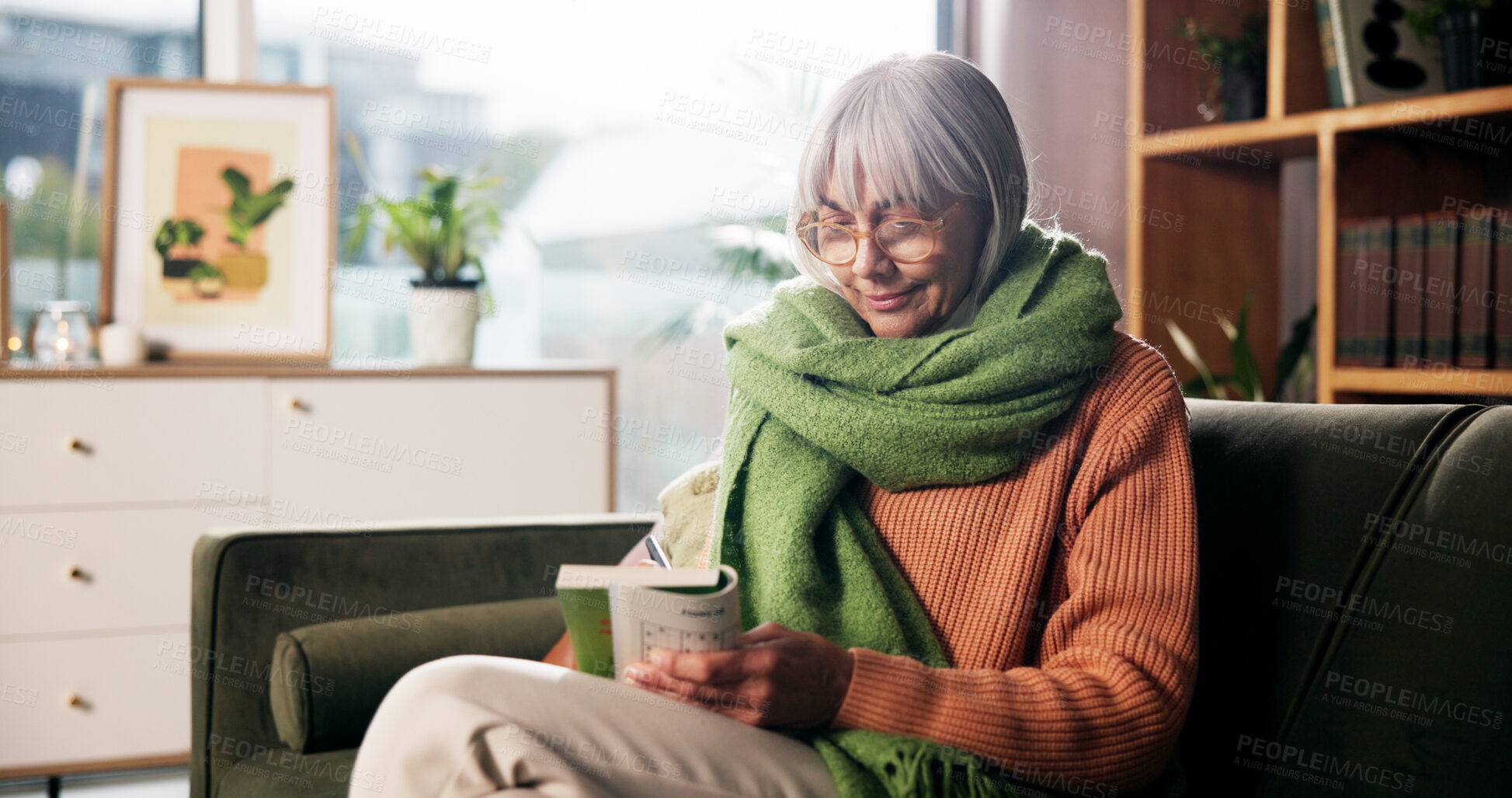 Buy stock photo Game, writing and book with old woman on sofa for smile, brain puzzle and relax. Hobby solution, reading and problem solving with elderly person in living room of home for answer, idea and journal