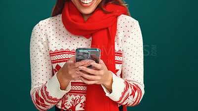 Buy stock photo Christmas, ecommerce and hands with smartphone, studio or online shopping for festive season on web. Green background, happy and person with xmas sweater, mobile app or scroll for holiday discount
