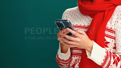Buy stock photo Christmas, online shopping and hands with smartphone, studio and planning for festive season on web. Green background, mockup space and person with xmas sweater, mobile or scroll for holiday discount