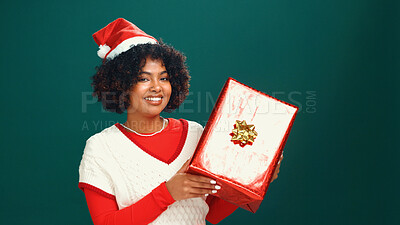 Buy stock photo Christmas hat, portrait and black woman with gift in studio for tradition, festive or celebration. Happy, holiday and African female person with present box for xmas event by green background.
