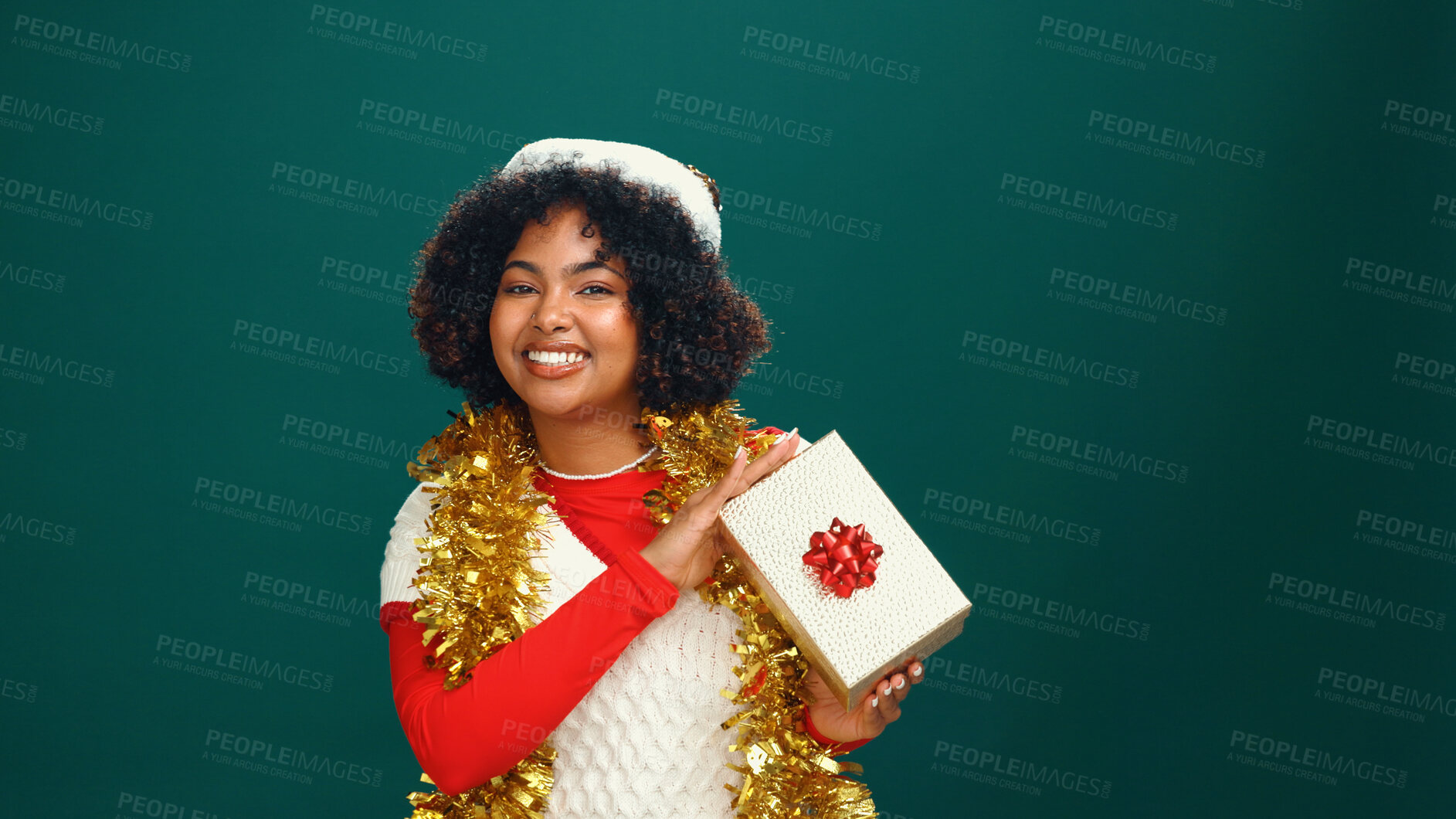 Buy stock photo Santa hat, portrait and black woman with present in studio for Christmas tradition, festive or celebration. Happy, holiday and African female person with gift box for xmas event by green background.
