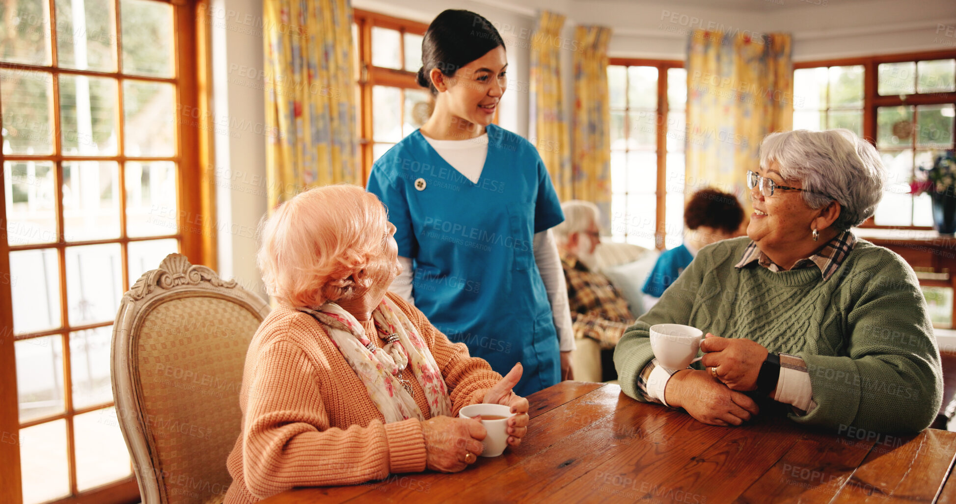 Buy stock photo Nursing home, caregiver and old women with coffee, chat and conversation for healthcare or wellness. Assisted living, nurse and talking to elderly people, retirement and happy with tea in house