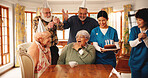 Surprise, senior people and birthday cake in nursing home for celebration, laugh and excited. Special day, friends and shock at party event, wow and social gathering with medical team in retirement