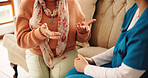 Hands, nurse and senior person on sofa with conversation, healthcare assessment and support in retirement. People, caregiver and elderly patient on couch, consultation and explain symptoms in house