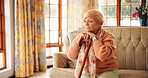 Walking stick, memory and senior woman in home with thinking, retirement or remember nostalgia. Ideas, wood cane and elderly female person with a disability on sofa with daydreaming in house.