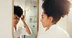 Woman, hair check and mirror in  bathroom with texture, grooming and care for natural growth. Morning routine, haircare and African person with curl volume, reflection and smile for cosmetics
