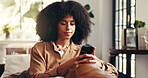 Woman, relax and phone on sofa for social media, connectivity and text message in home. African girl, mobile and typing in living room for research, status update and forum discussion on internet