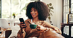 Woman, coffee and phone on sofa for social media, connectivity and text message with smile. African girl, mobile and drink in home for communication, status update and forum discussion on internet