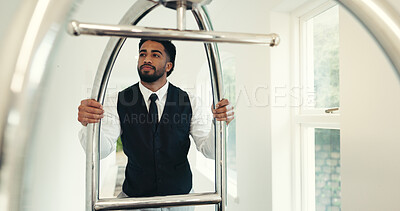 Buy stock photo Porter, service and push trolley in hotel for luggage handling, check in welcome and guest arrival. Employee, hospitality and man with cart at luxury resort for bellboy assistance, concierge and help