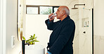 Bathroom, mirror and senior man drinking water for hydration in morning with getting ready. Relax, retirement and elderly male person with health drink for break with preparing for day in home.