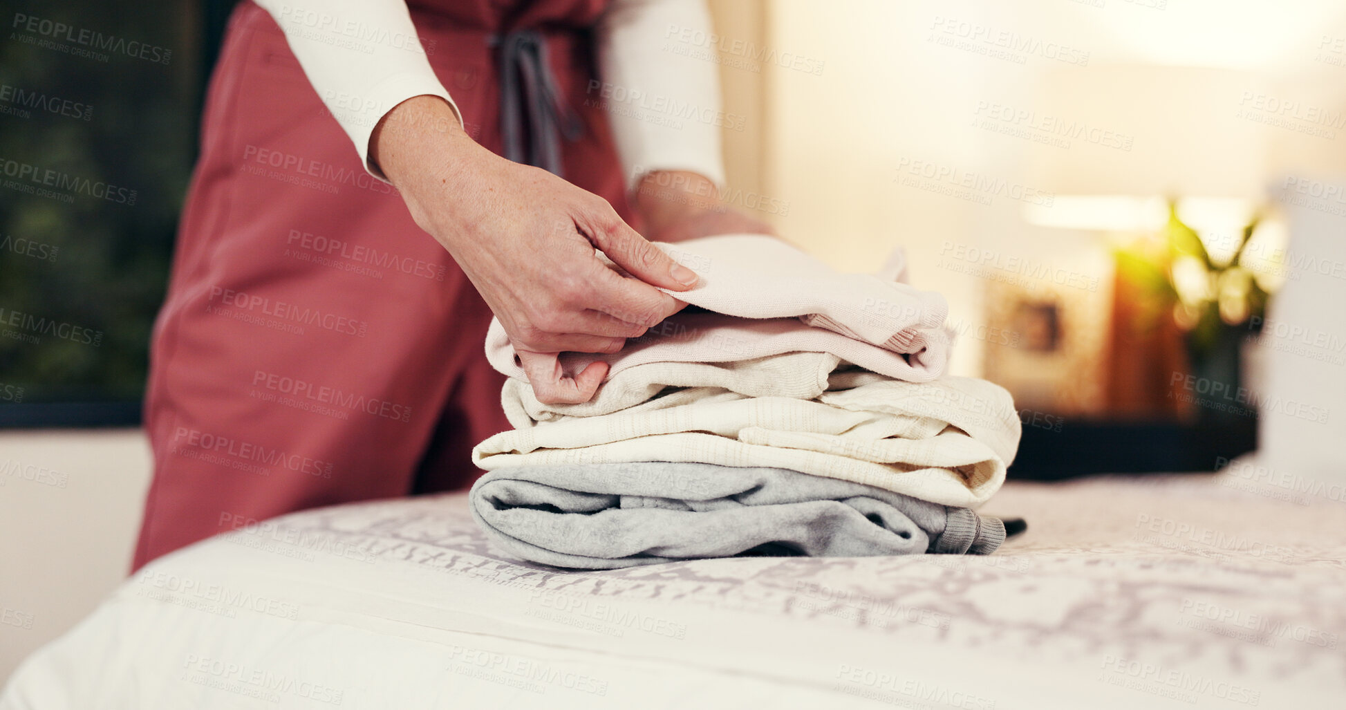 Buy stock photo Hands folding laundry, bed and house for hygiene routine, services and nurse in bedroom. Person, caregiver and packing clean clothes with garments, fabric or assisted living career at retirement home