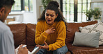 Sad, anxiety and woman on sofa for therapy, session and support for healing with therapist. Psychology, mental health and person talking to social worker for consulting, discussion and evaluation