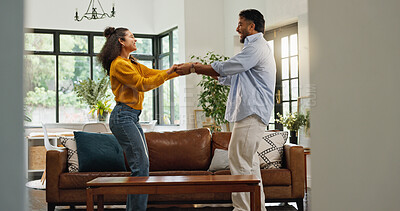 Buy stock photo Happy couple, dancing and excited in living room, home and love with celebration for goals. People, man and woman with moving, rhythm or holding hands for partnership, relationship or care at house