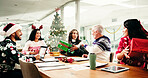 Christmas, meeting and business people with gift in office party for holiday celebration. Xmas, happy workers and exchange present, giving and festive discussion with funny joke for secret santa