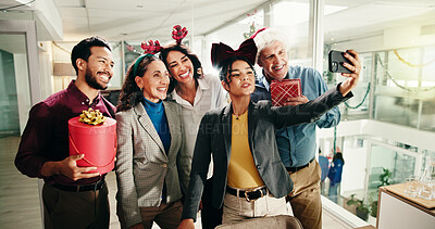 Buy stock photo Christmas, business people and team selfie in office for photography with gift. Xmas picture, friends and happy workers with holiday spirit, December celebration or memory for social media at party