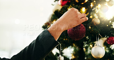 Buy stock photo Christmas tree, decoration and hand of person in home for celebration or December holidays. Bauble, glitter and hanging with woman in living room of apartment for festive season or tradition space