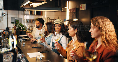 Buy stock photo Talking, group and friends with wine tasting at pub for experience, social gathering and bonding. Night, people and swirling alcohol at restaurant for quality testing, weekend break or prepare flavor