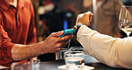 Person, hands and pos machine with watch for payment, wireless transaction or easy banking in bar. Closeup, customer or bartender with wristwatch or NFC for buying, EFT or ecommerce in restaurant