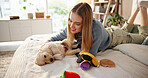 Happy, playing and woman with puppy on bed for learning, development and bonding after adoption. Pet owner, bedroom and person with Golden Retriever dog for relaxing, relationship and animal care