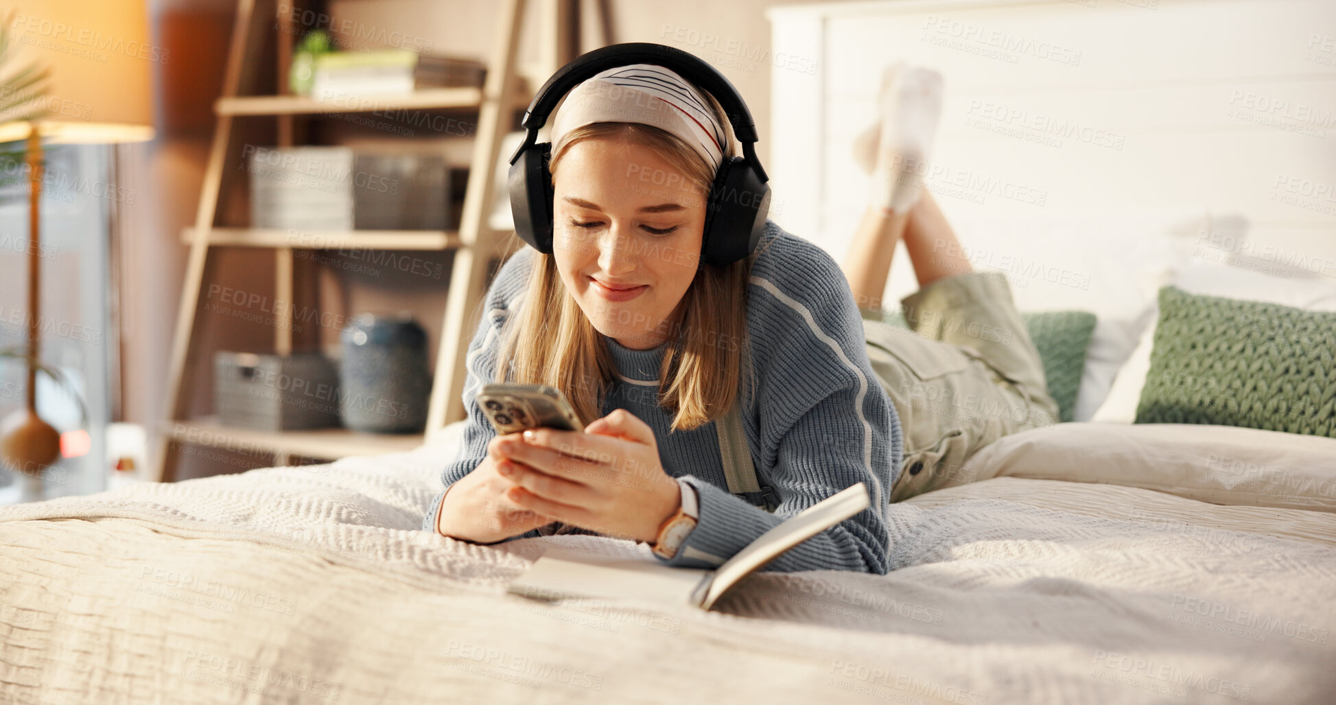Buy stock photo Happy, bed and woman with headphones and notebook for relaxing, writing in journal and social media. Bedroom, chill and person with phone listening to audio, radio and streaming music for inspiration