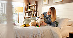 Bed, playing and woman with puppies in home with smile for bonding, relationship and adoption. Happy, pet owner and person with Golden Retriever dog in bedroom with toys for relax, cuddle and care