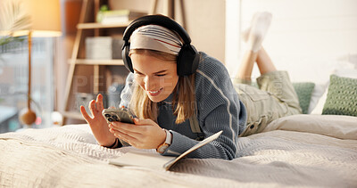 Buy stock photo Phone, bedroom and woman with headphones in home for relaxing, writing in journal and social media. Happy, smile and person on smartphone listening to audio, radio and streaming music for inspiration
