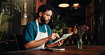 Waiter, man and typing on tablet in cafe for stock order, email supplier and inventory management. Small business, manager and digital app in restaurant for menu planning and check sales performance