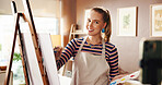 Artist, canvas or woman with phone for live streaming in studio with creative tips, advice or vlog. Influencer, painter and happy with video recording for painting process, art technique and skills