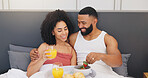 Happy couple, relax and breakfast with orange juice or strawberries in bed for healthy diet in home. Man, woman or lovers with smile in bedroom for snack, nutrition or natural organic fruit in house