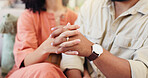 Closeup, couple and holding hands in home with love, marriage and connection with care in lounge. People, partnership and support with loyalty, trust and relax together in living room at apartment