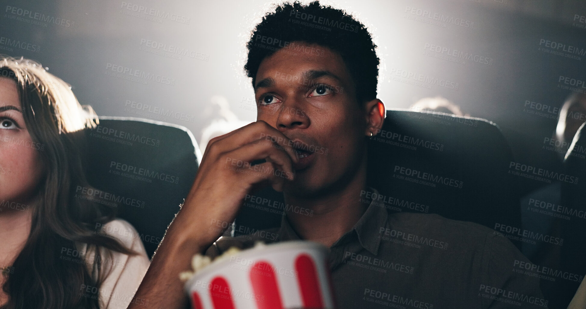 Buy stock photo Man, popcorn and suspense movie at theater with snack, audience and entertainment at film screening. Person, eating and thriller video with crowd, fast food and scared with horror show at cinema