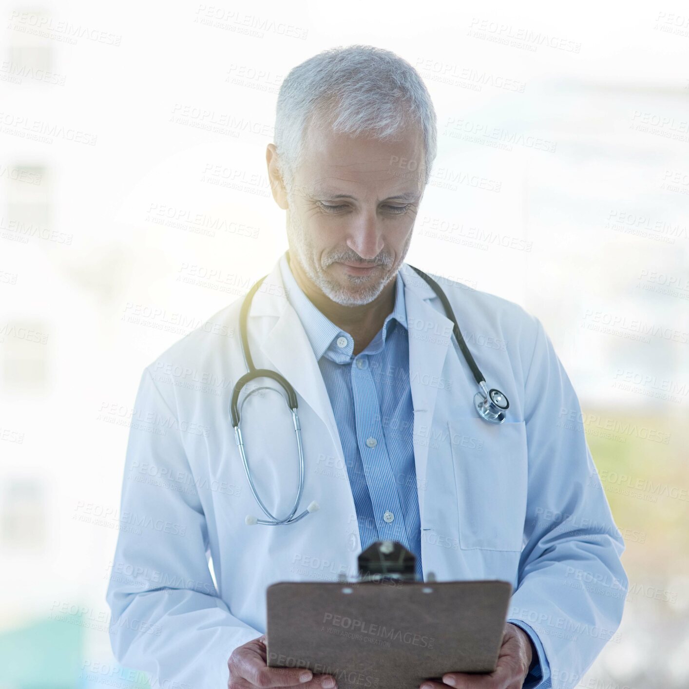 Buy stock photo Doctor, clipboard and stethoscope in hospital for medical research, examination or consultation with records. Physician, male person and mature at health, chart and results for healthcare or medicine