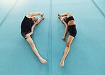 Gymnastics, fitness and people training in a gym stretching and preparing for a competition. Active, workout and strong man and woman practicing agility and flexibility for a competitive sport
