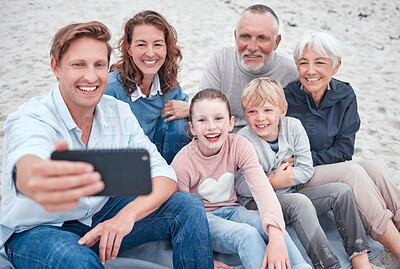 Buy stock photo Family, generations and selfie, together and happy on outdoor adventure at beach, smartphone and technology. Parents, grandparents and children smile, spending quality time and bonding at the coast.