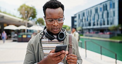 Buy stock photo Outdoor, student and black man with cellphone, typing and reading of message, notification and results for exam. Campus, mobile and person with scholarship in college, serious and fail of test online