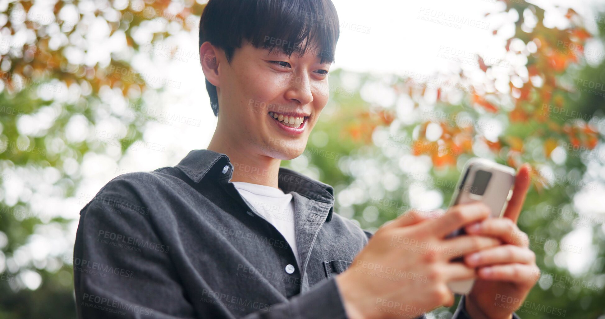 Buy stock photo Smile, man and relax with phone at park for travel guide, communication and location directions. Happy, person and mobile for contact, abroad chat and vacation information of morning commute in Japan