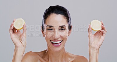 Buy stock photo Portrait, lemon and woman with skincare, smile and dermatology on gray studio background. Mature person, organic cosmetics and model with confidence, citrus and natural detox with wellness and facial