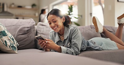 Buy stock photo Home, funny and teenage girl on sofa, smartphone or typing with smile, online humor or text. Apartment, laughing or happy person with cellphone, joke or digital app for message to contact or internet