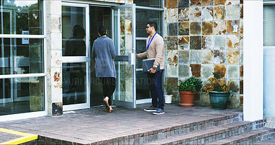 Buy stock photo Walking, woman and man holding door for arrival at company, morning and travel to meeting. Open, colleague or friendly people with work, team and together for commute, gratitude and help or start
