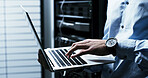 Hands, typing and laptop with programming in server room, coding or IT solution at company. Person, cybersecurity and assessment with computer, hardware or information technology for system upgrade