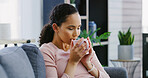 Coffee, calm and woman on sofa in house with relax, peaceful or morning on weekend break. Happy, tea and female person drinking warm beverage or latte with smile on couch in living room at apartment.
