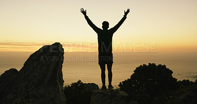 Buy stock photo Person, celebration and silhouette on mountain with hiking, goals or success on trekking route. Hiker, hands up and cheers for achievement, ocean view or fitness on rocks with sunset sky in Colombia