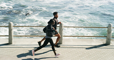 Buy stock photo Exercise, people and running at beach promenade for burning calories, endurance or cardio routine. Above, athlete and coach jogging at ocean for pace training, sports performance or fitness challenge