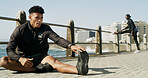 Man, fitness and stretching with leg for warm up or flexibility on outdoor promenade. Active, male person or runner with workout preparation or foot for physical exercise or training on sidewalk