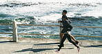 Fitness, people and running at beach promenade for burning calories, endurance or exercise routine. Cardio team, above and jogging at ocean for pace training, sports performance and workout challenge