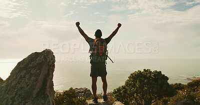 Buy stock photo Man, celebration and hiking on mountain, sky and fist pump for success, clouds and ocean in summer. Person, trekking and freedom on trail, summit or outdoor with back view for achievement in nature