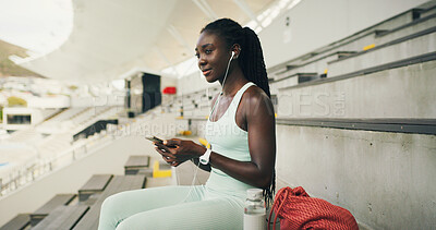 Buy stock photo Earphones, athlete and woman with smartphone, stadium and listening to music with tech and thinking. Streaming, audio and black person with mobile, fitness and reflection for marathon, break or rest