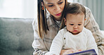 Development, education or reading with baby and mother on sofa in living room of home for growth. Book, future or story with infant and single parent woman in apartment for learning or teaching