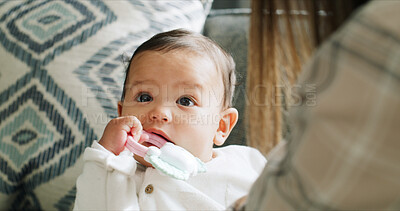 Buy stock photo Child, baby girl and chewing toys in living room with mom, home and development or growth and teething progress. Kid, face and biting rattle in mouth for tooth, gums and playing in house lounge