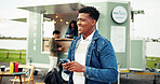 Food truck, man and phone with search outdoor for online menu, cafe review and waiting on date. Happy, person and smartphone at mobile coffee shop for customer experience, weekend break or networking